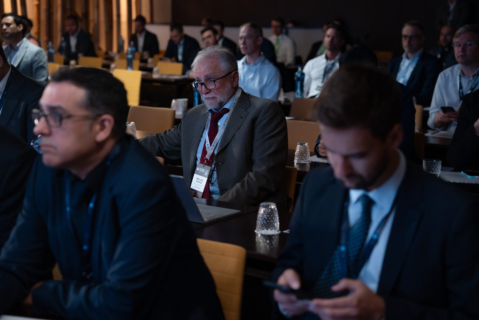 Delegates attentively listening to expert presentations in a packed conference hall.